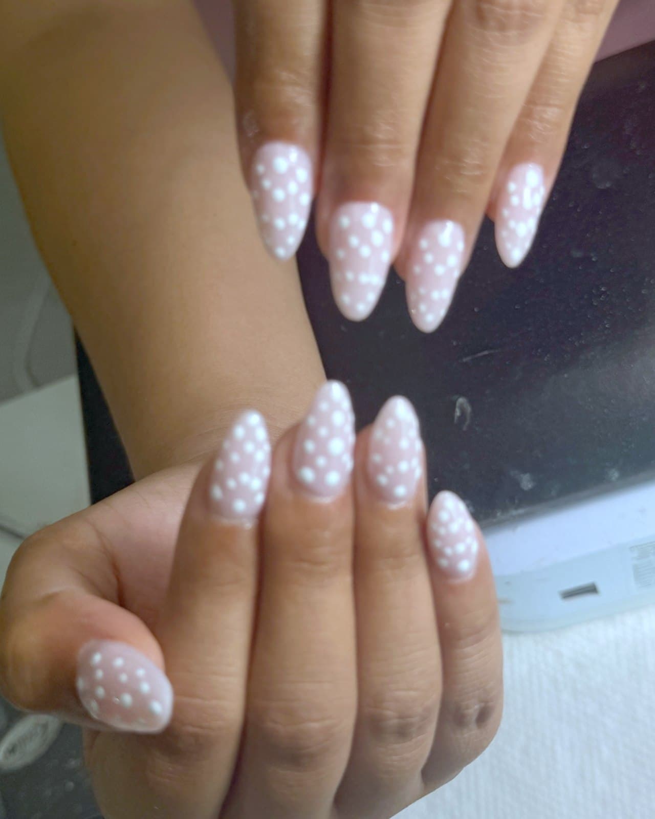 Ongles amande rose poudré avec pois blancs