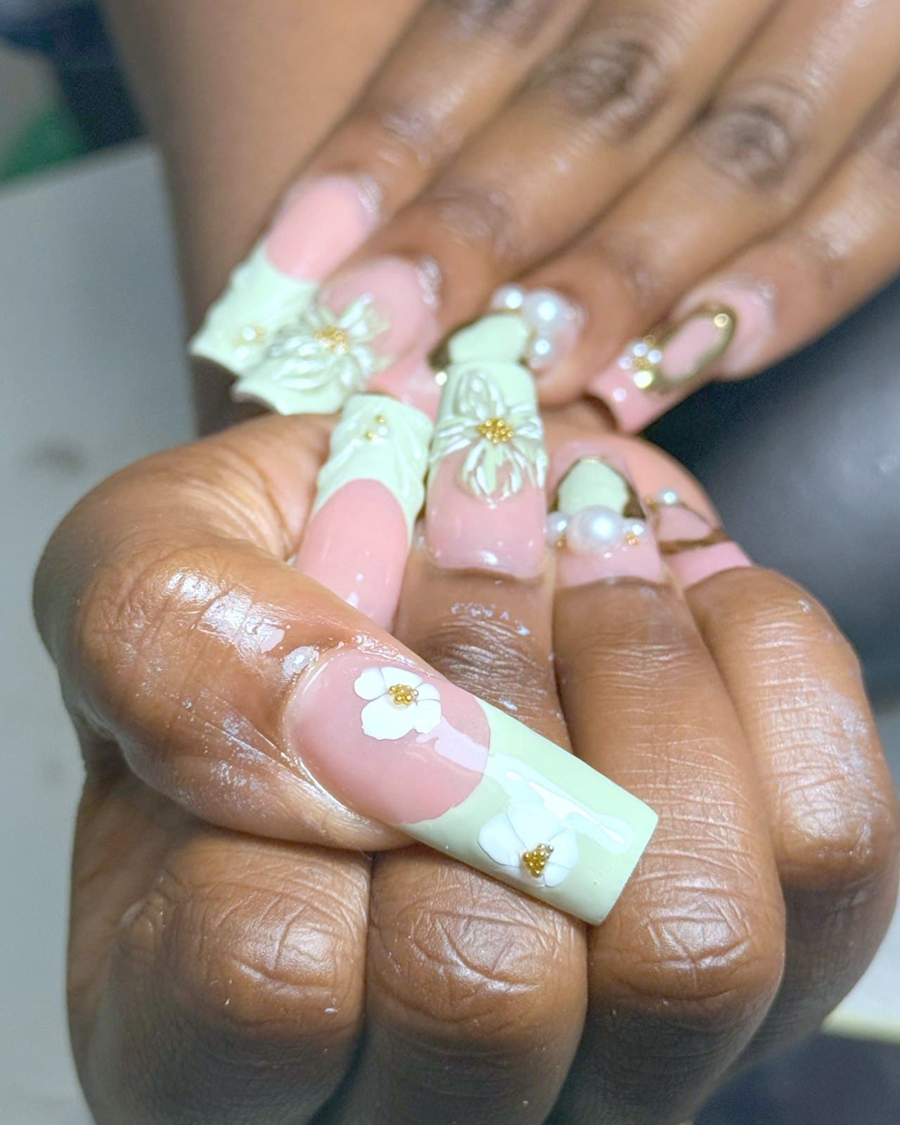 Ongles longs French vert sauge avec fleurs 3D blanches, perles et billes dorées